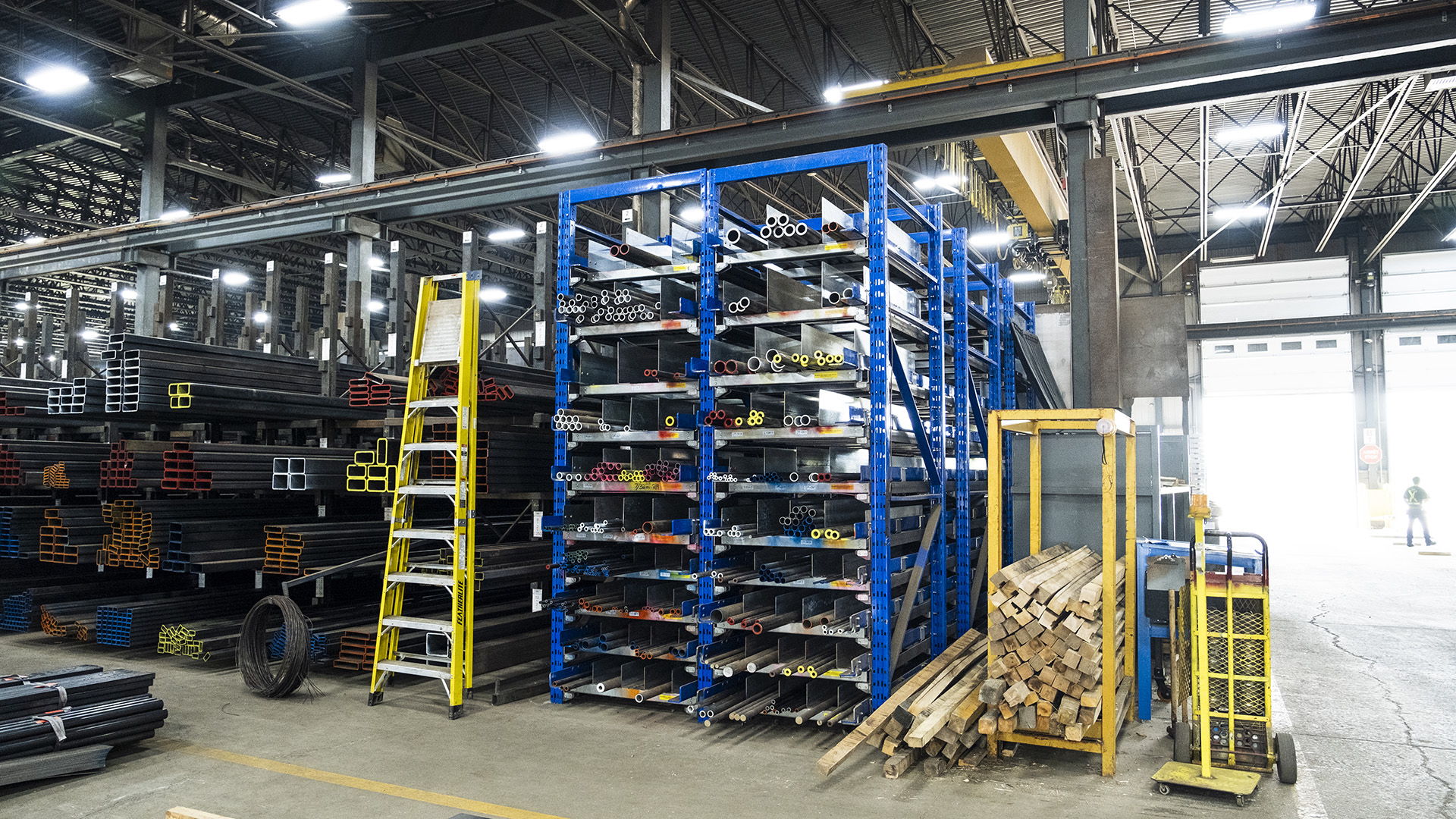 Industrial warehouse with shelving unit and ladders for storage organization.
