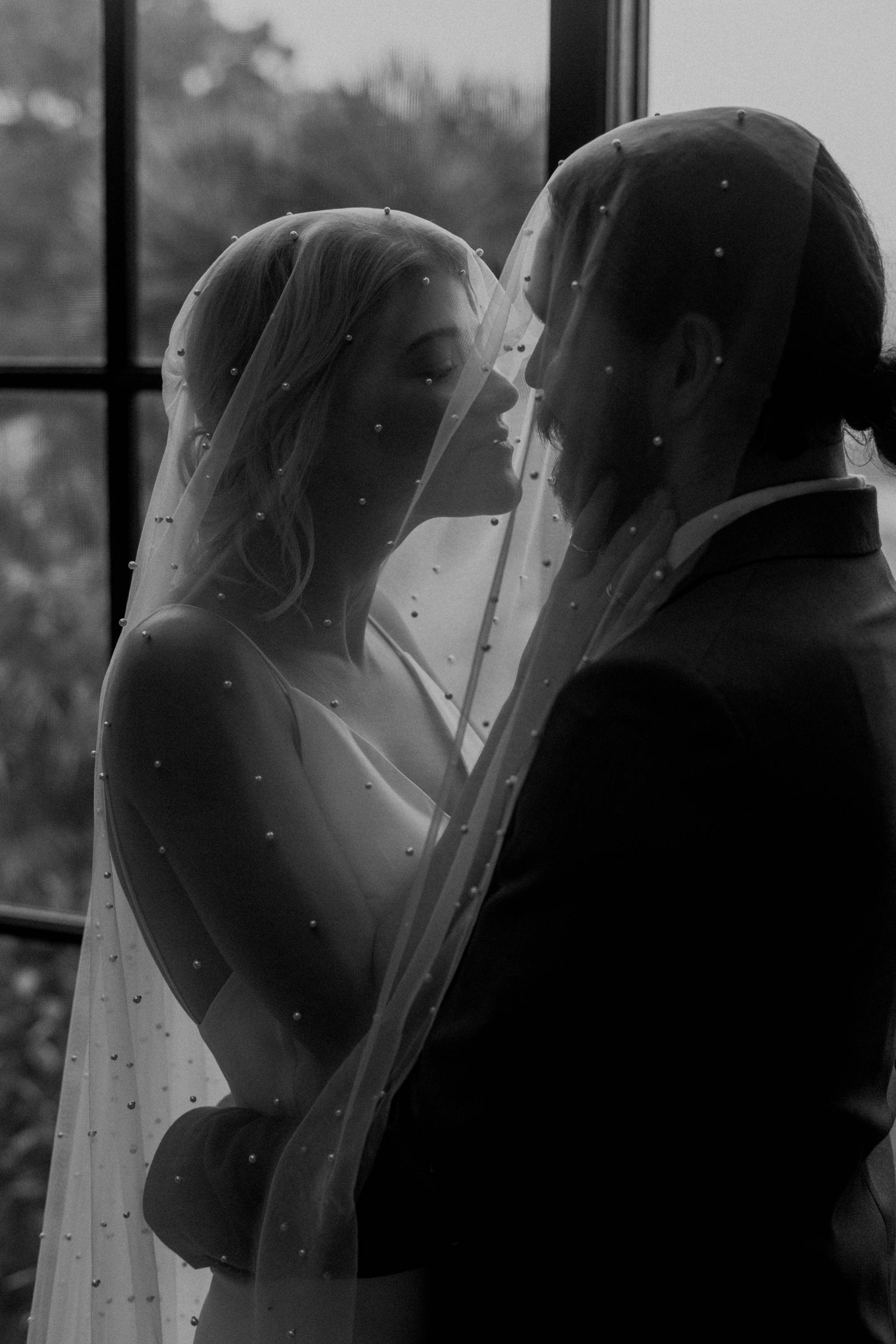 Grace Loves Lace bride and her groom underneath the pearly long veil 