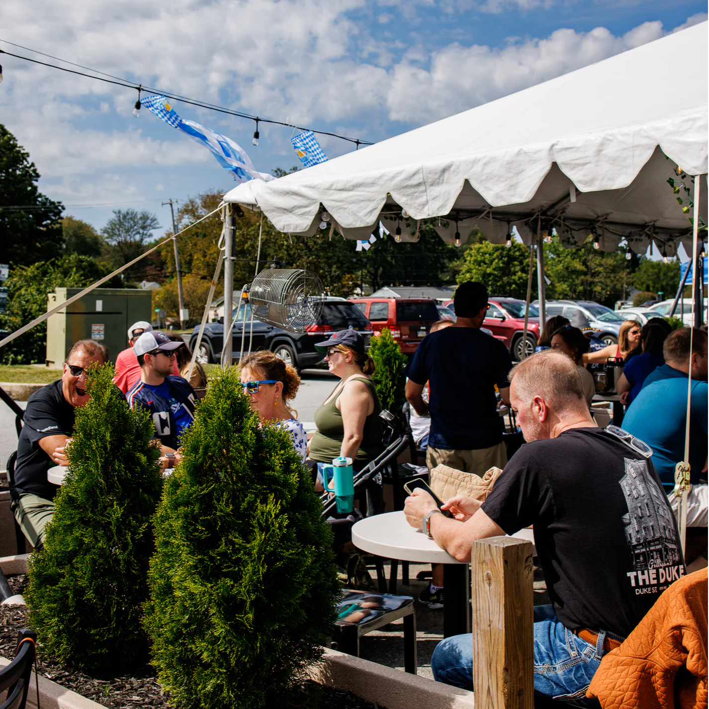 people gathering on a tented patio