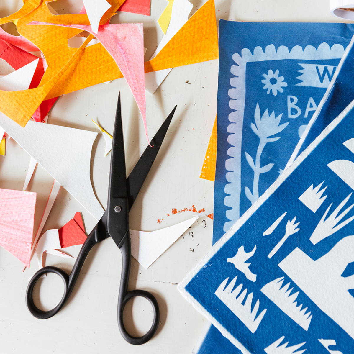 A photograph of scissors and paper cuttings.