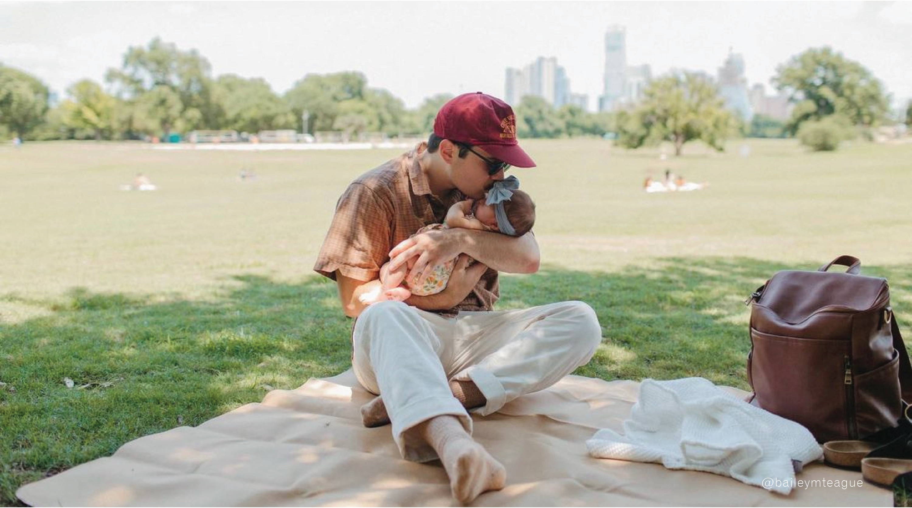 Dad kissing baby on Gathre Mat in the park