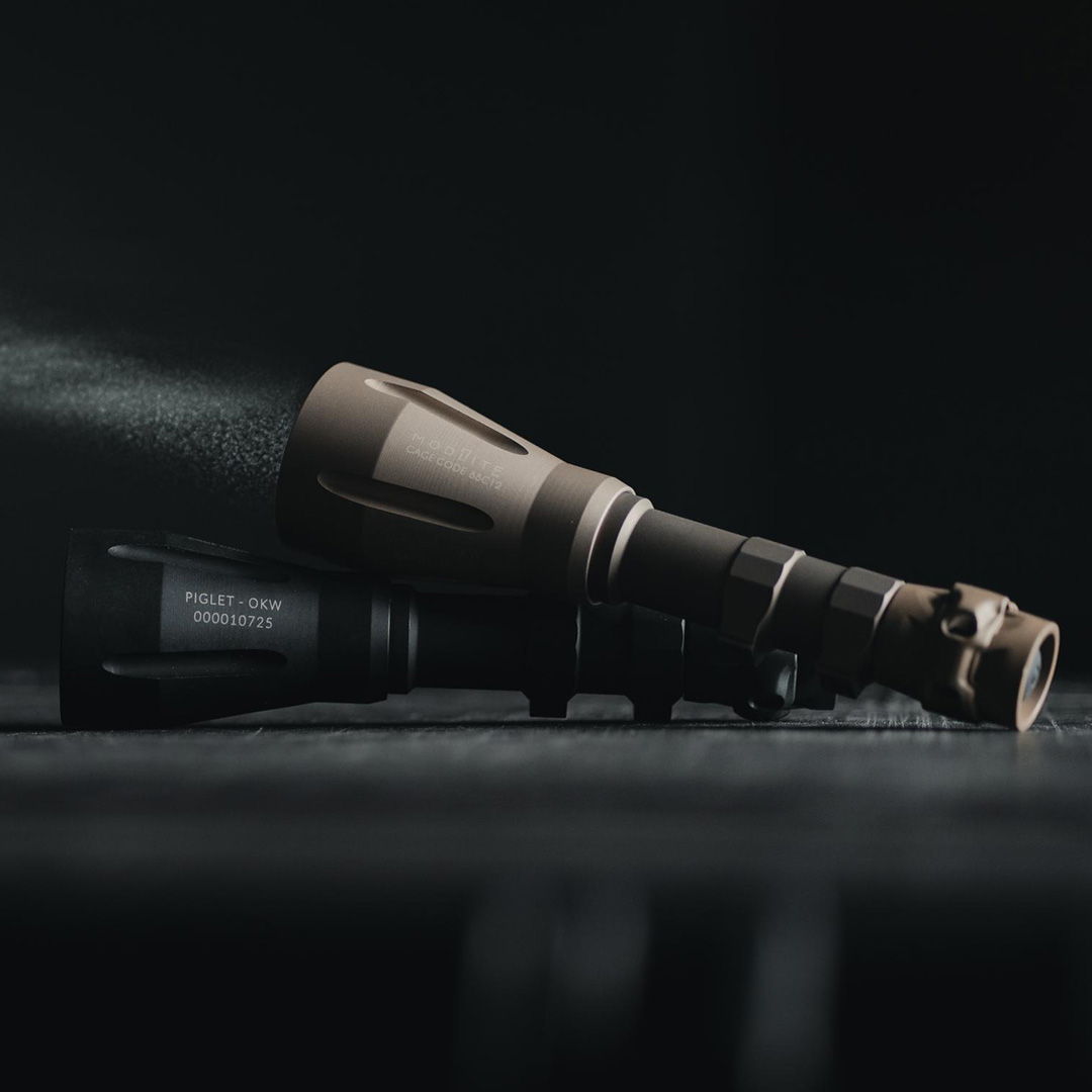 Two flashlights resting on a surface with light beams visible.