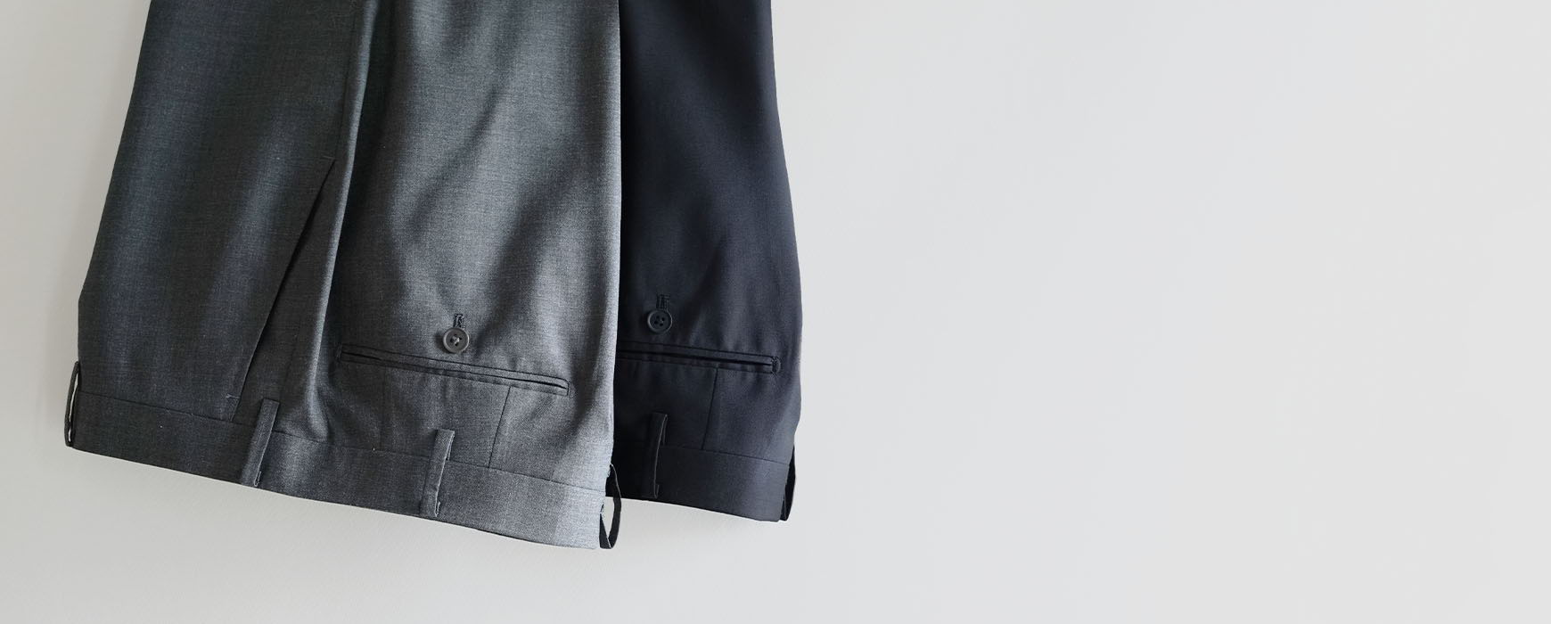 A black leather jacket hanging against a white wall.