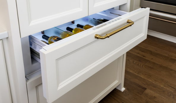 Open white drawer with bottles illuminated inside.