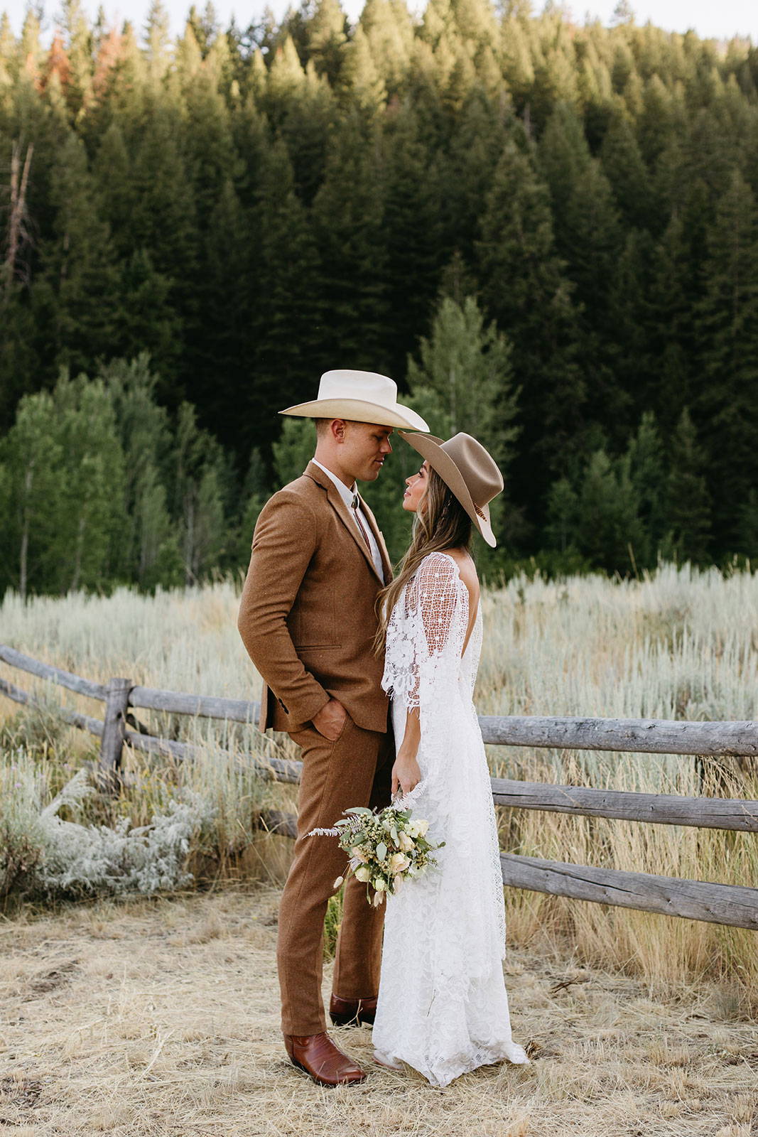 Bride and Groom in country hats, looking at each other