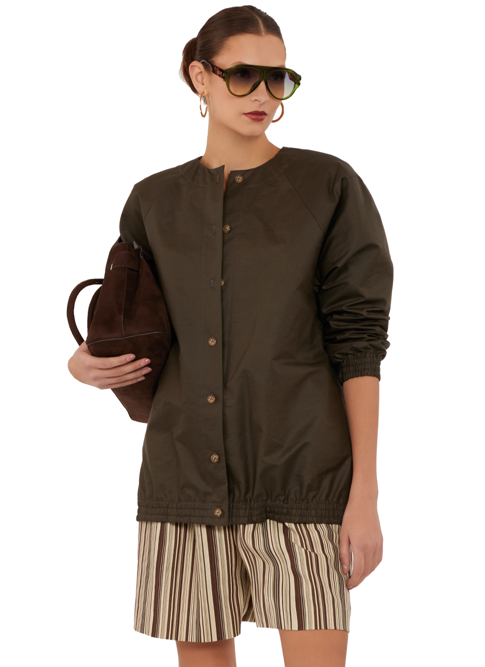 Woman in sunglasses wearing a jacket and striped shorts, holding a handbag.