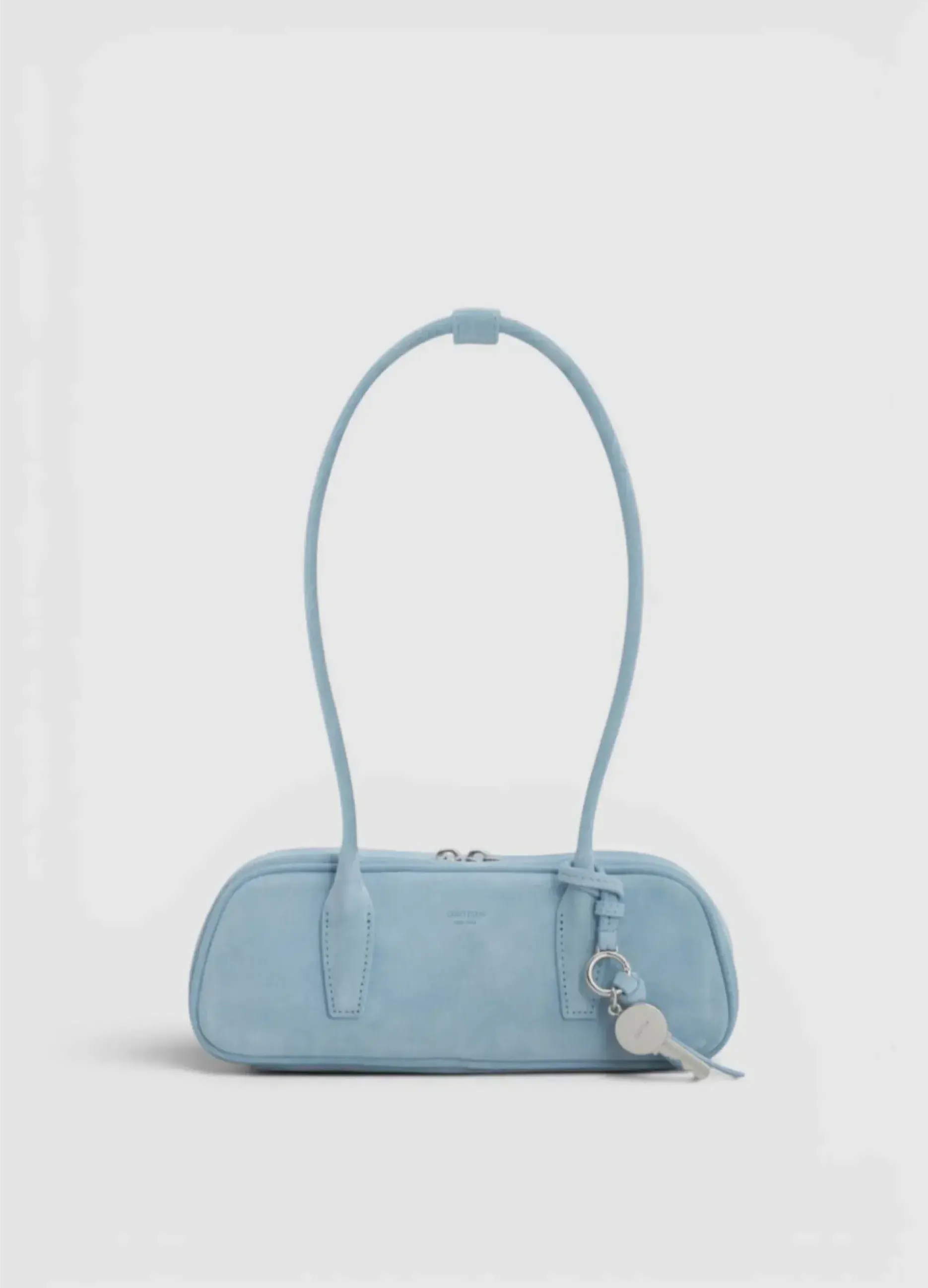Light blue handbag with a long handle and keychain.