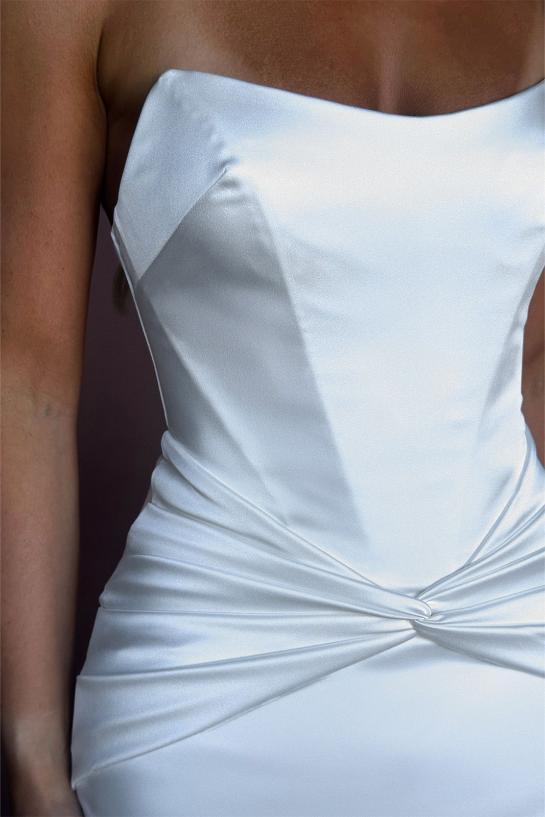 White strapless dress with a twisted detail at the waist.