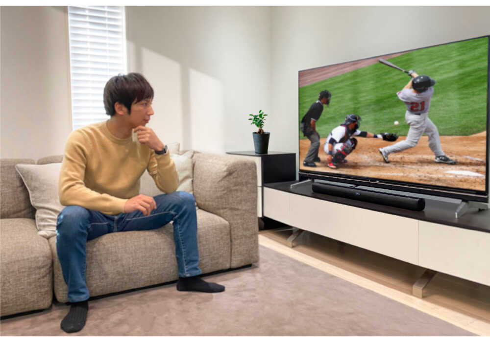 リビングで野球のテレビを見る男性の画像。テレビの前にはFunLogy SOUND3が置いてある。