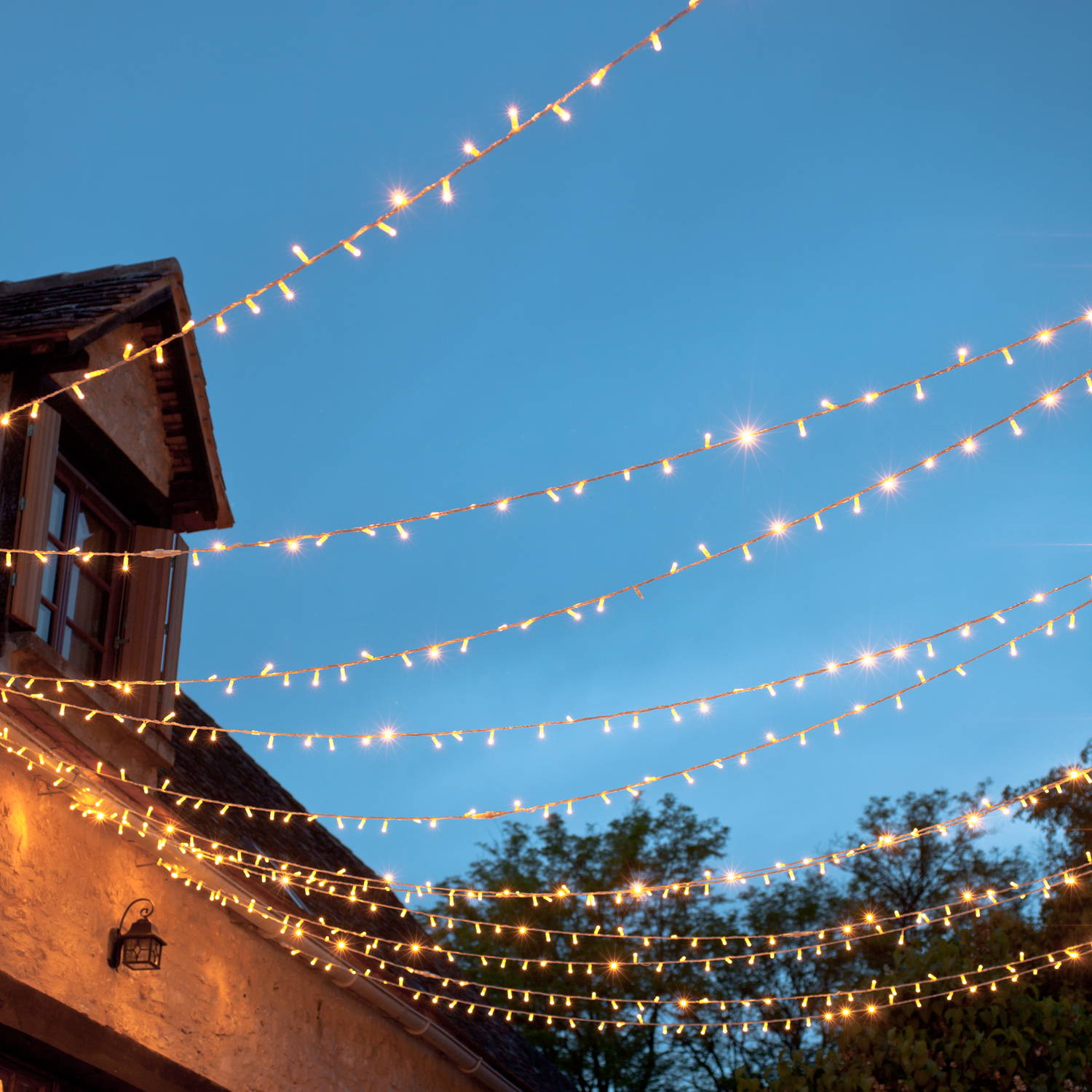 Over head string lights creating a glowing ceiling outdoors