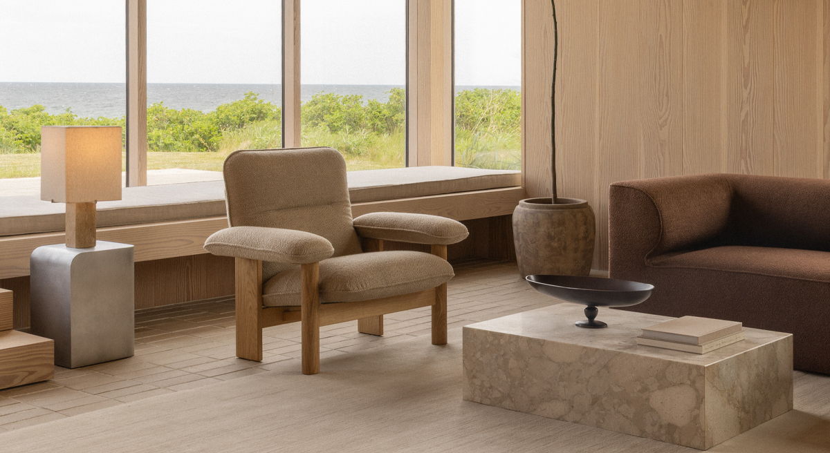 A stylish beige Audo armchair with a unique, curved design.
