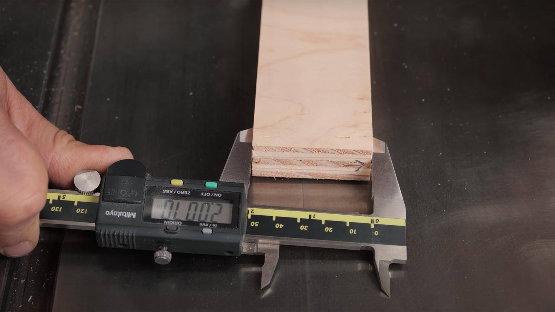 using calipers to measure the width of a board