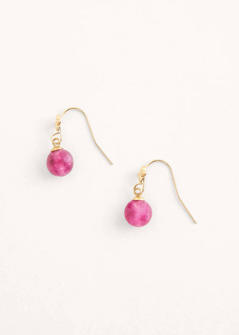 A pair of gold earrings with a pink circular crystal pendant