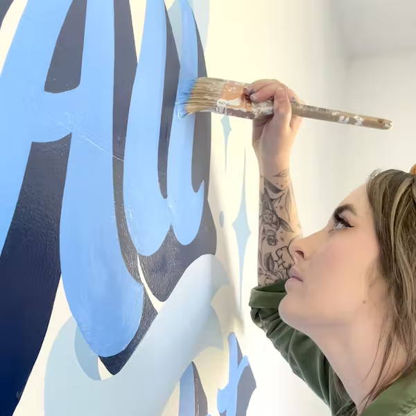 Marley Soden painting a mural