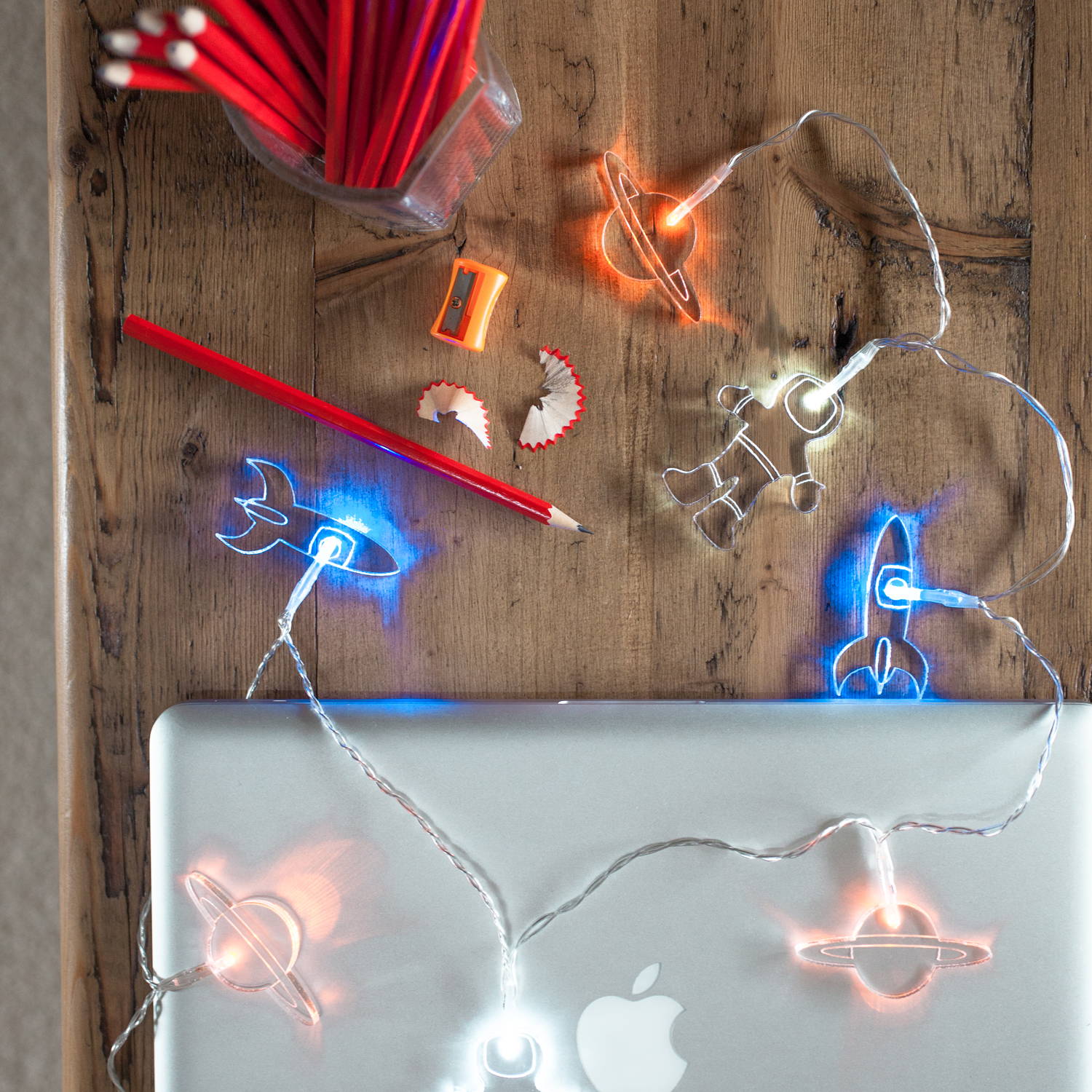 Spaceman battery fairy lights on desk table with pencil pot and laptop