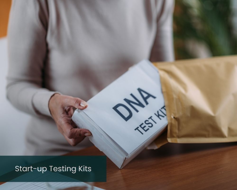Person holding a DNA test kit next to a package on a table.