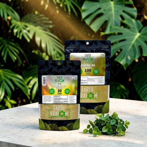 Two packets of herbal supplements on a stone table surrounded by green plants.