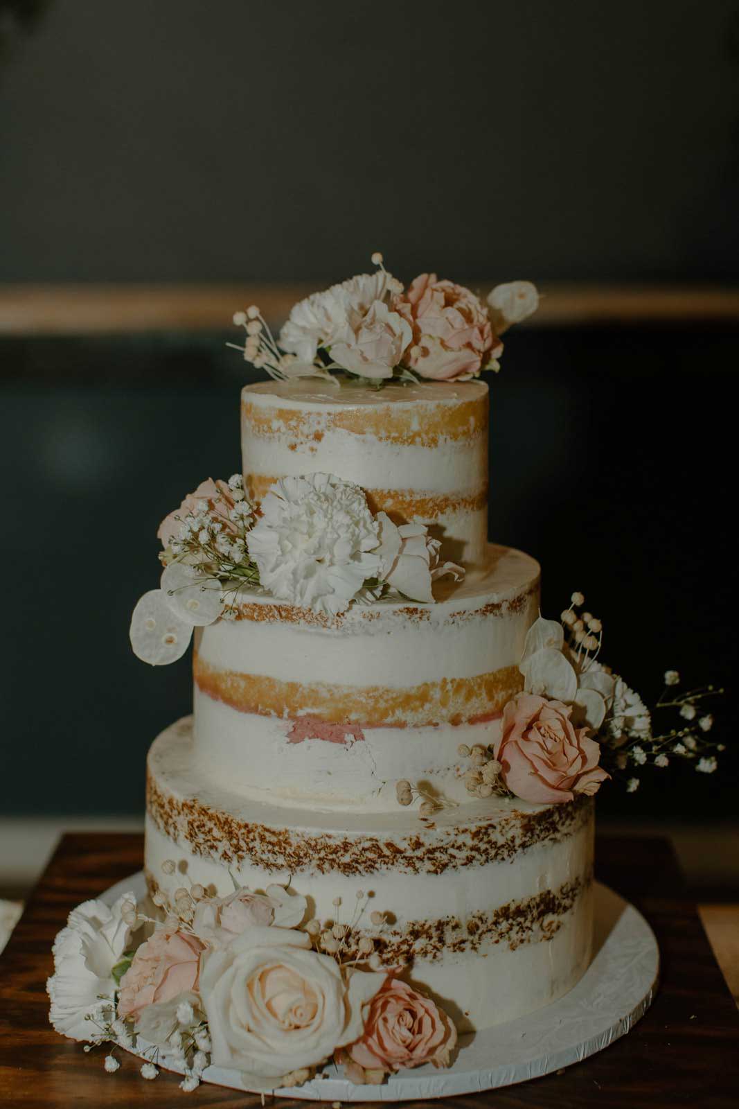 Hochzeitstorte mit aufgesetztem Blumenschmuck