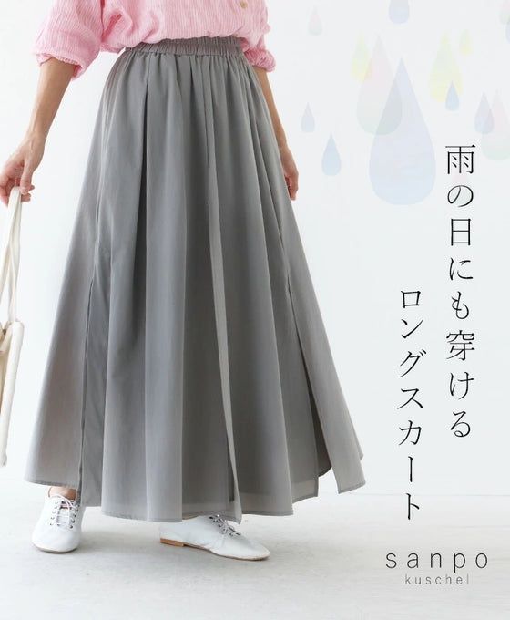 A person wearing a long gray skirt and pink top.