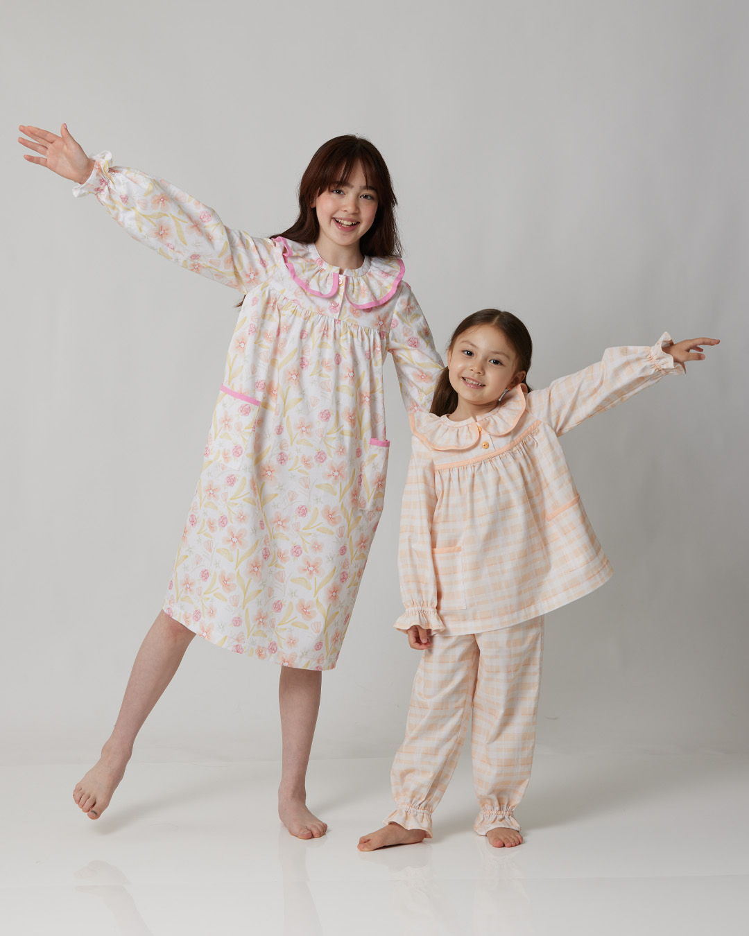 Two girls in matching pajamas posing playfully.