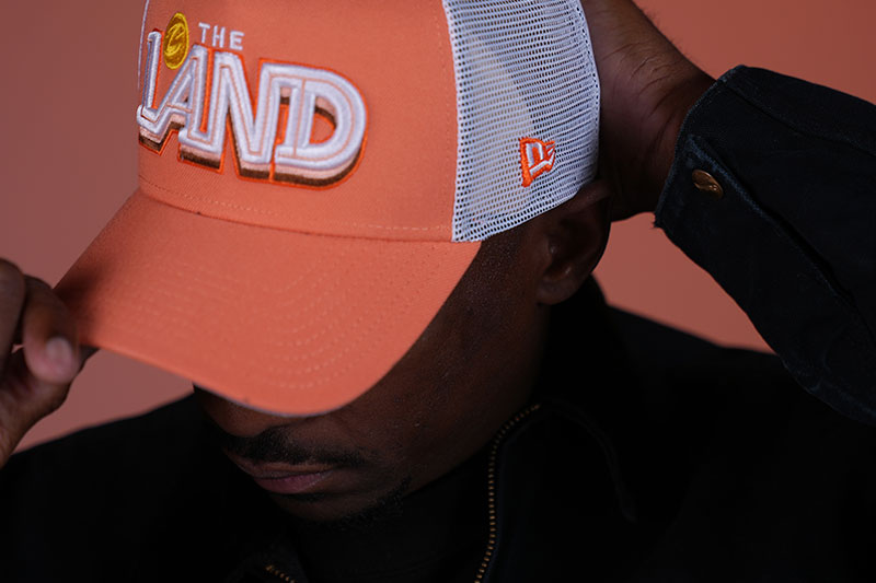 Person adjusting an orange cap with 