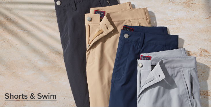 Four pairs of shorts displayed on a sandy background.
