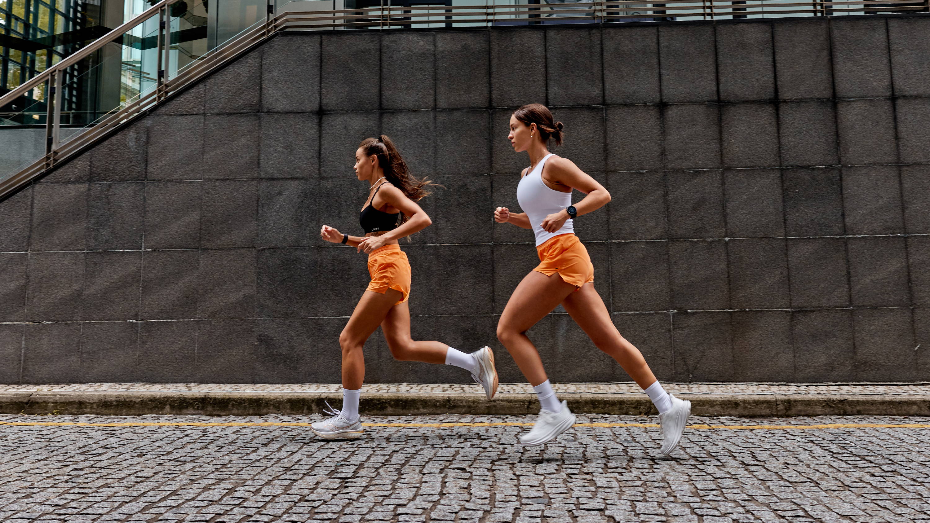 two girls running in the city