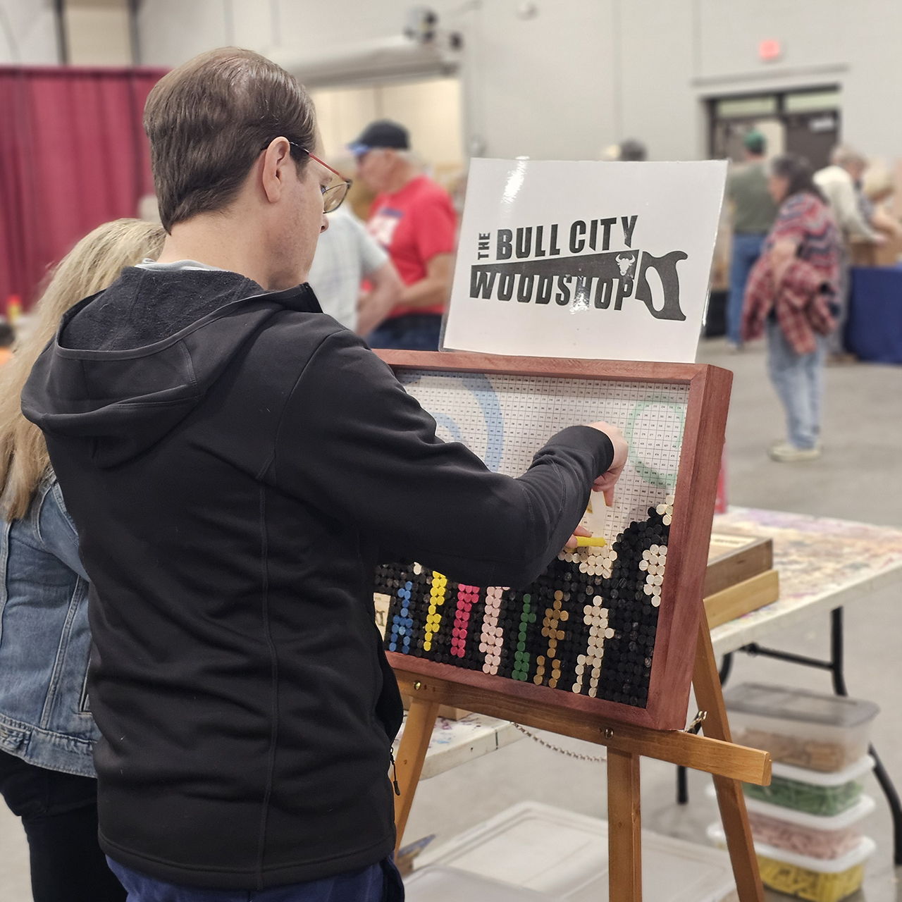 Person interacting with a colorful display at a craft fair.
