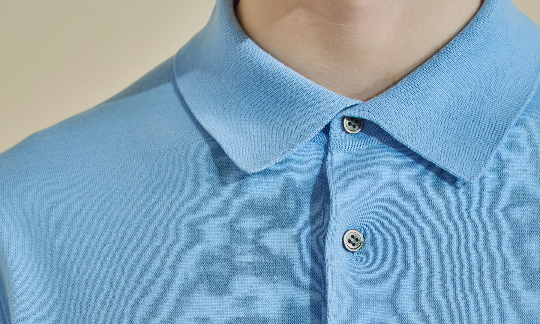 Close-up of a person wearing a light blue polo shirt.