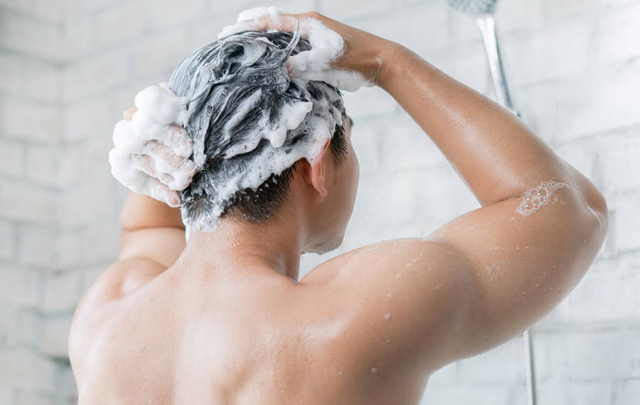 man in shower washing hair