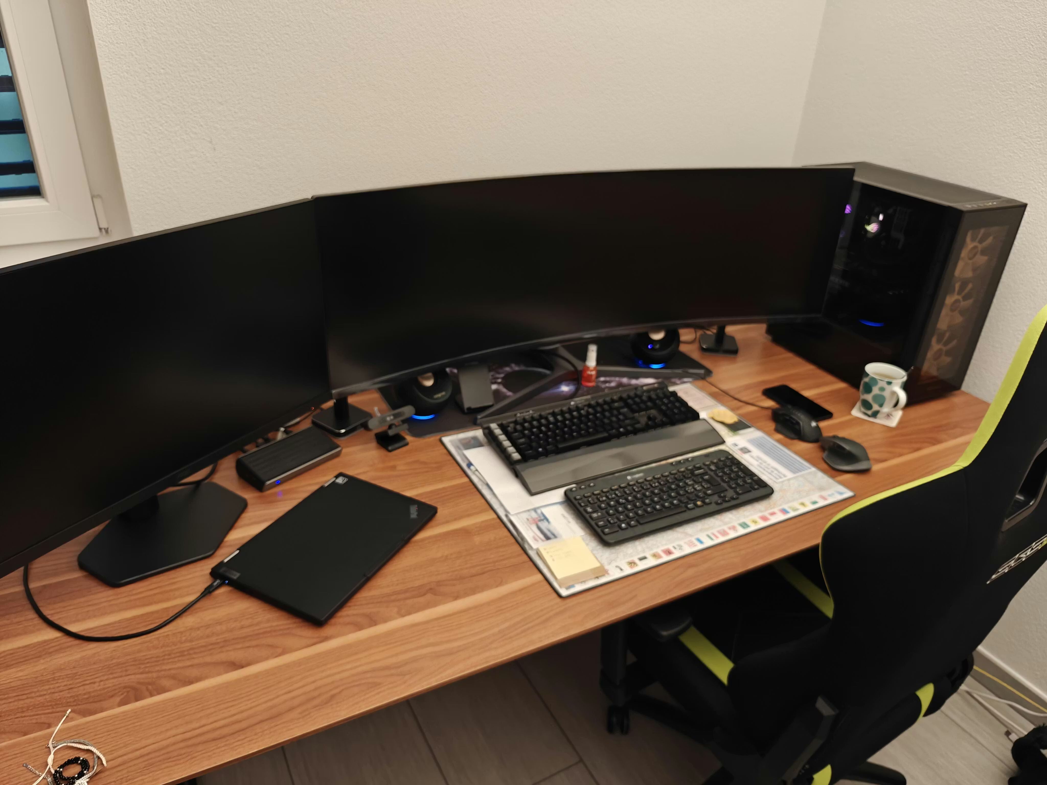 Elektrisch höhenverstellbarer Bürotisch Elevate von ofinto in der Tischplatten-Farbe Walnuss in einem modernen Homeoffice mit Computer, Bildschirmen und Tastatur auf dem Tisch