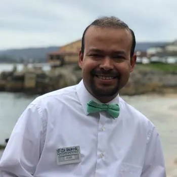 A waiter wearing a seafoam bow tie.