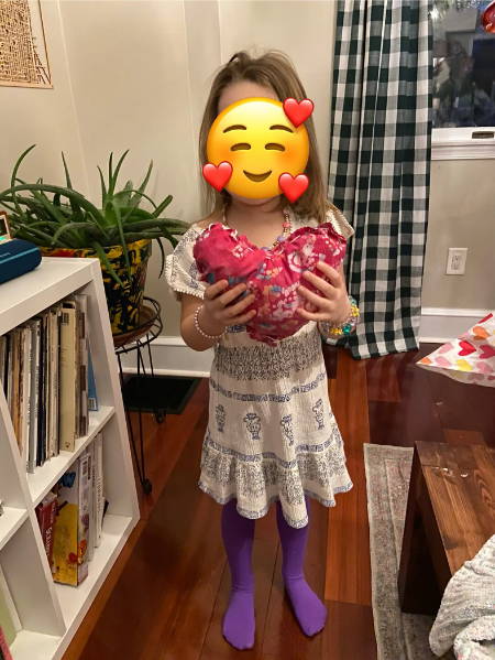 little girl showing her finished heart shaped pillow