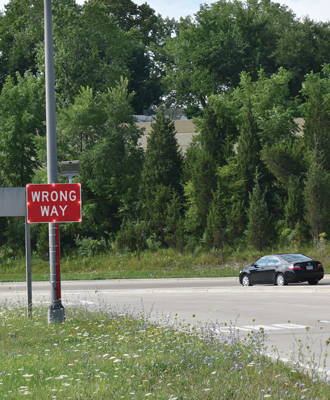 A flashing LED wrong-way sign alerts an oncoming driver.