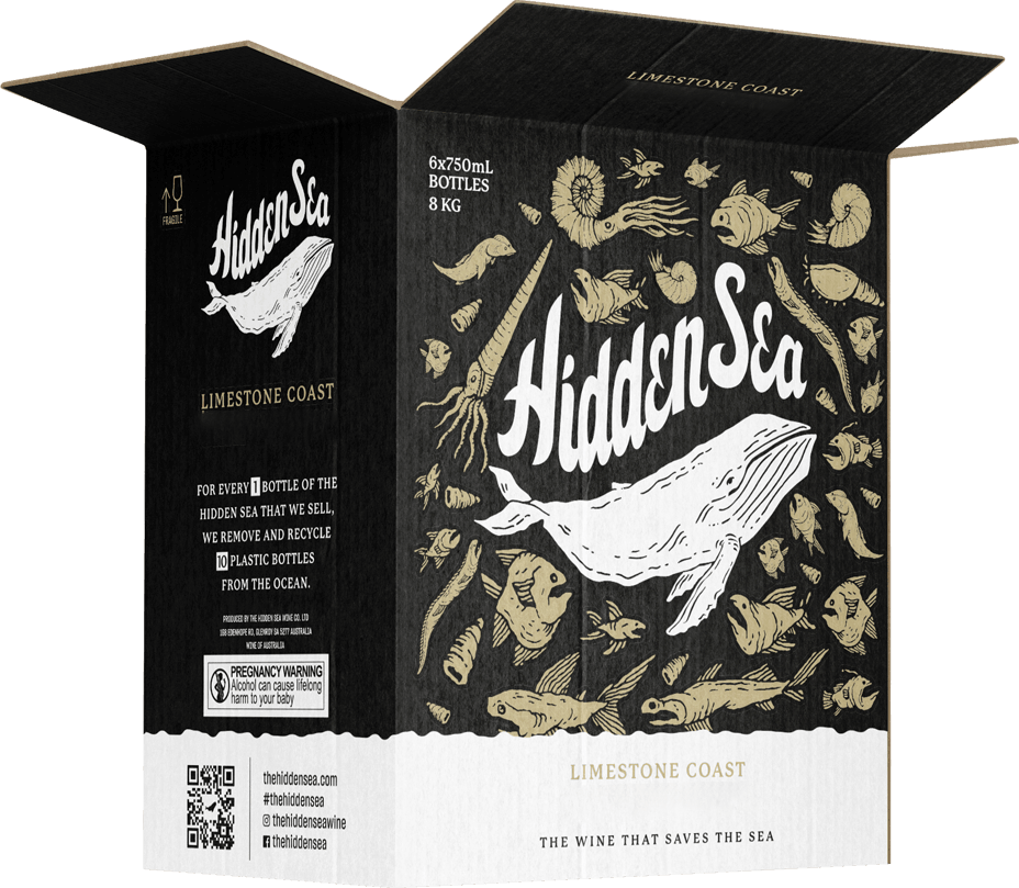 Open The Hidden Sea 6-bottle shipping case featuring a large white whale illustration on a black background with sea-life icons; side panel highlights the “10 plastic bottles removed” mission and includes a QR code and pregnancy warning label.