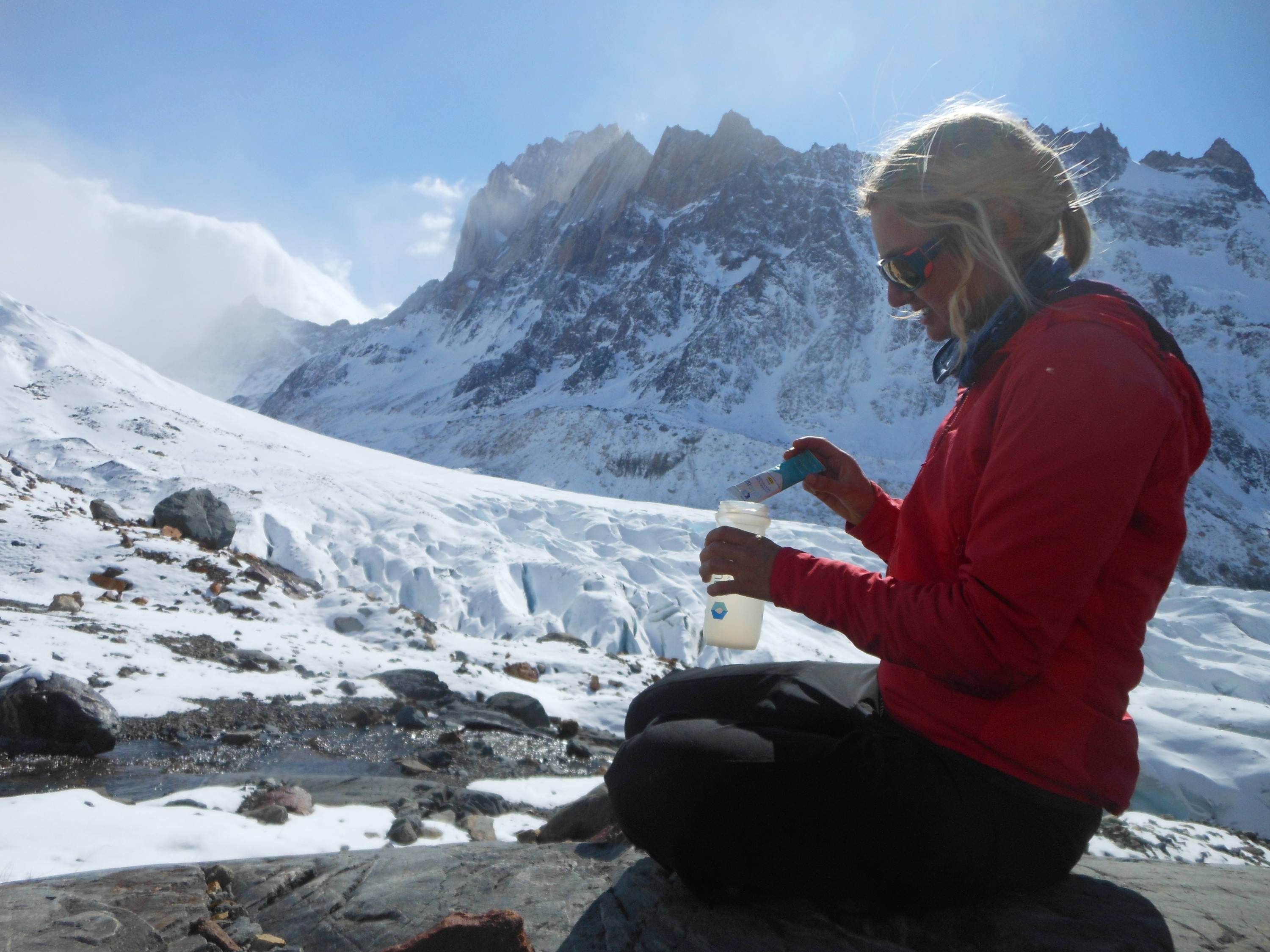 alpine athlete pours Liquid IV into her water bottle.