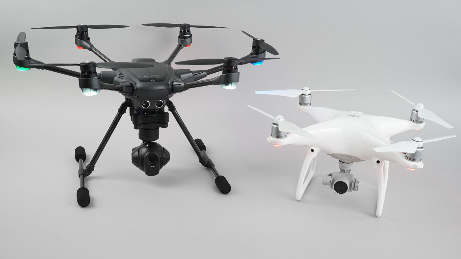 Typhoon H and Phantom 4 drones against a gray background.