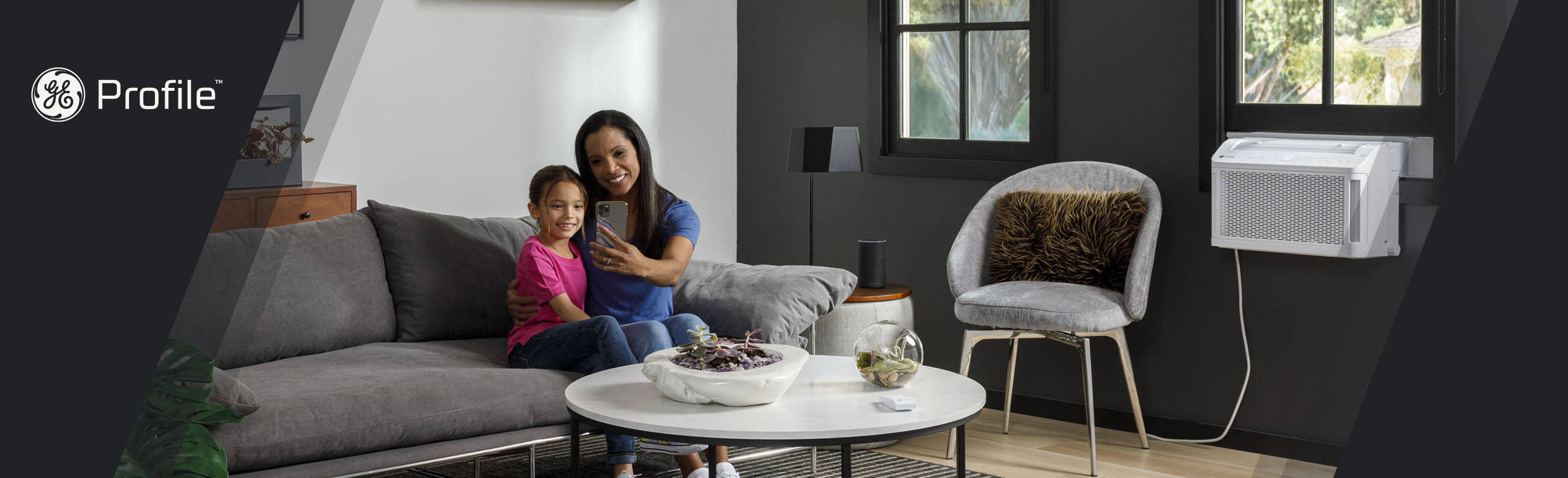 mom and daughter taking a selfie with GE Profile clearview air conditioner in the window.