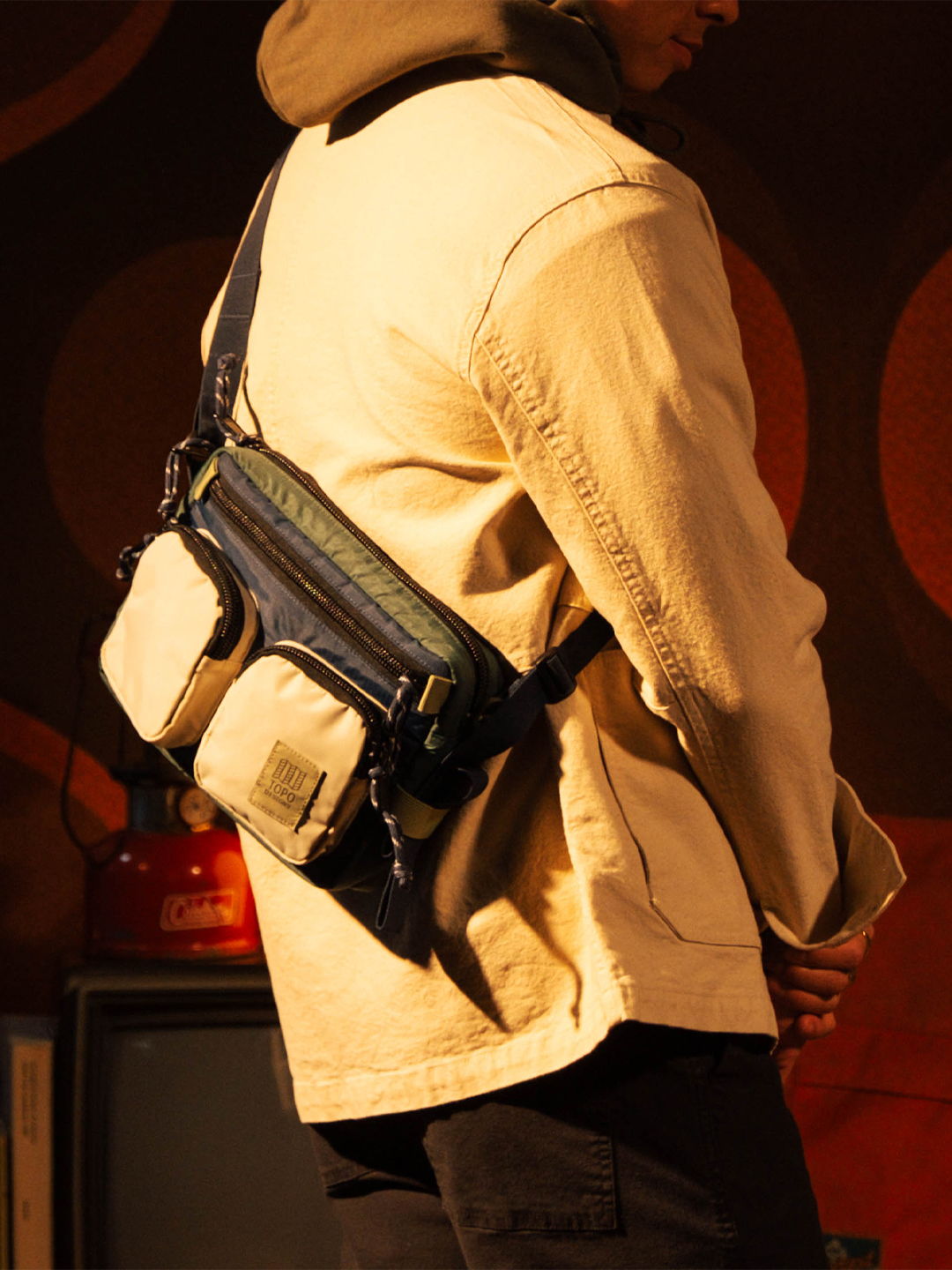 Person wearing a beige jacket and a crossbody bag.