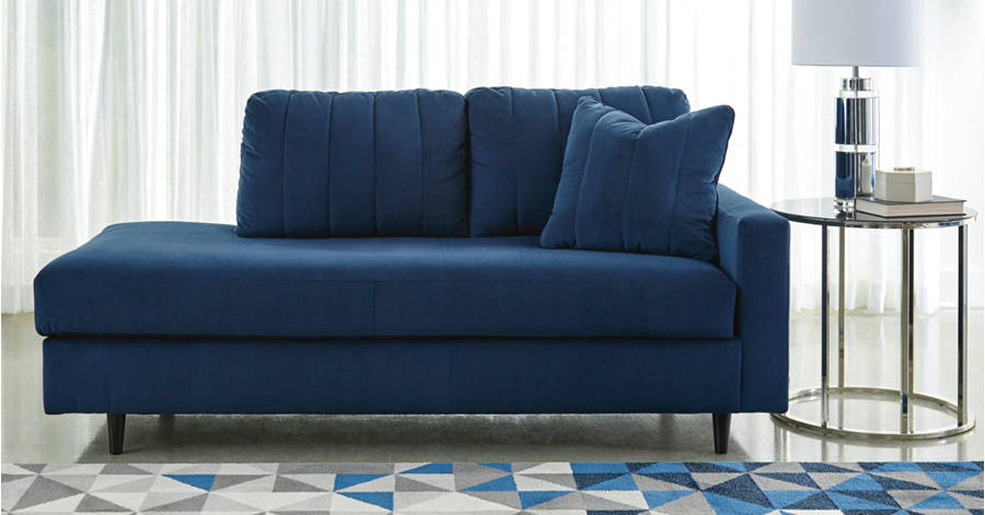 Deep blue chaise beside a geometric rug.