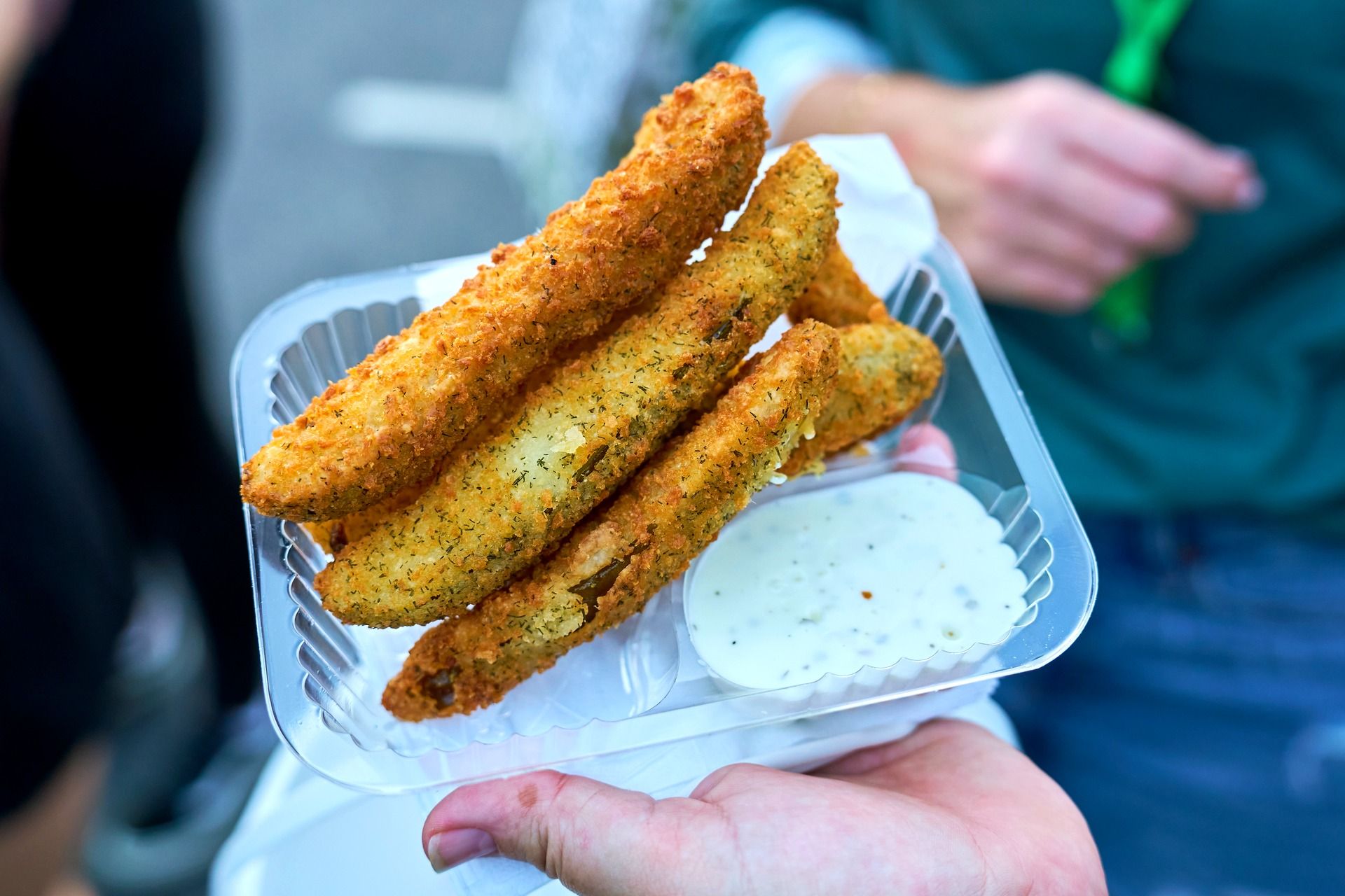 A festival guest holds a tray of golden fried pickle spears with ranch dipping sauce at The Big Dill pickle festival, Globe Life Field and Texas Live!, Arlington Texas 2025