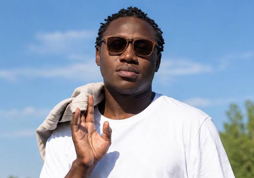 man with round face wearing square sunglasses and white tshirt