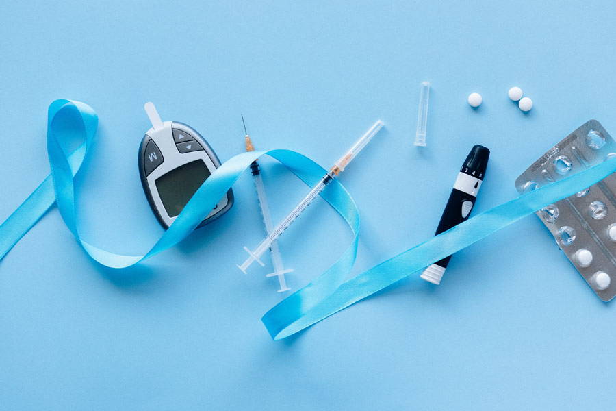 various diabetes supplies with a blue ribbon