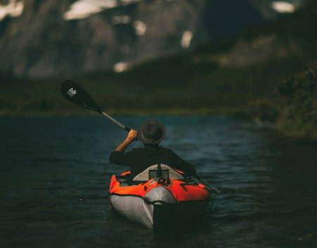 Photo of person paddling an inflatable raft.