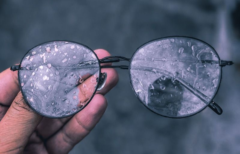 hand holding foggy and wet glasses due to weather