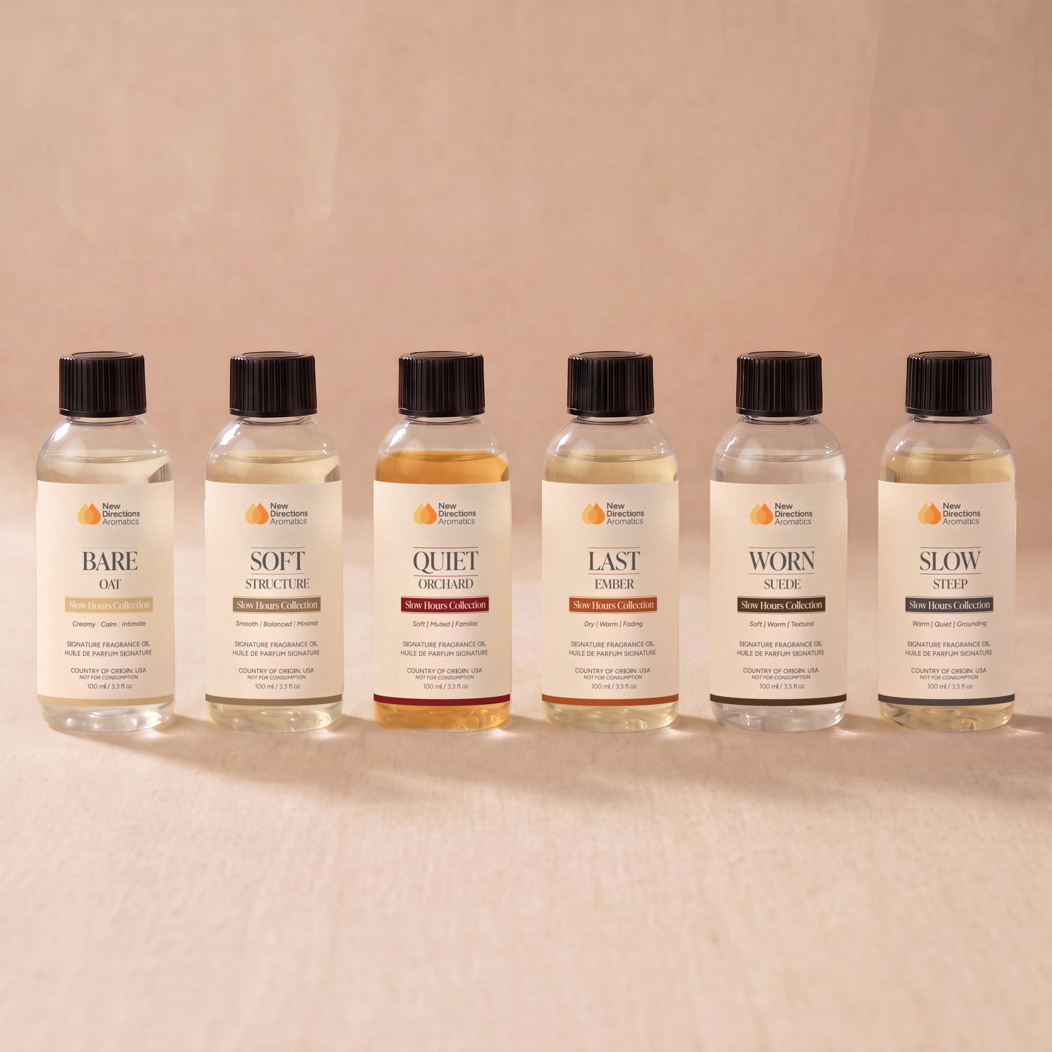 Six bottles of oils lined up against a neutral background.