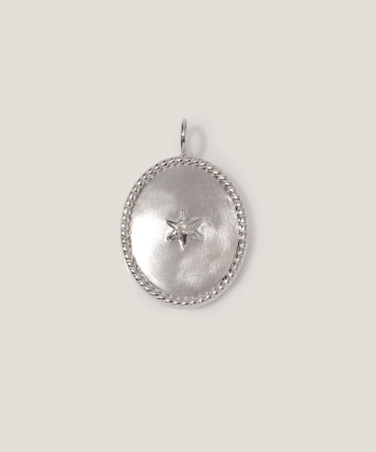 Silver pendant with a star design and decorative edge.