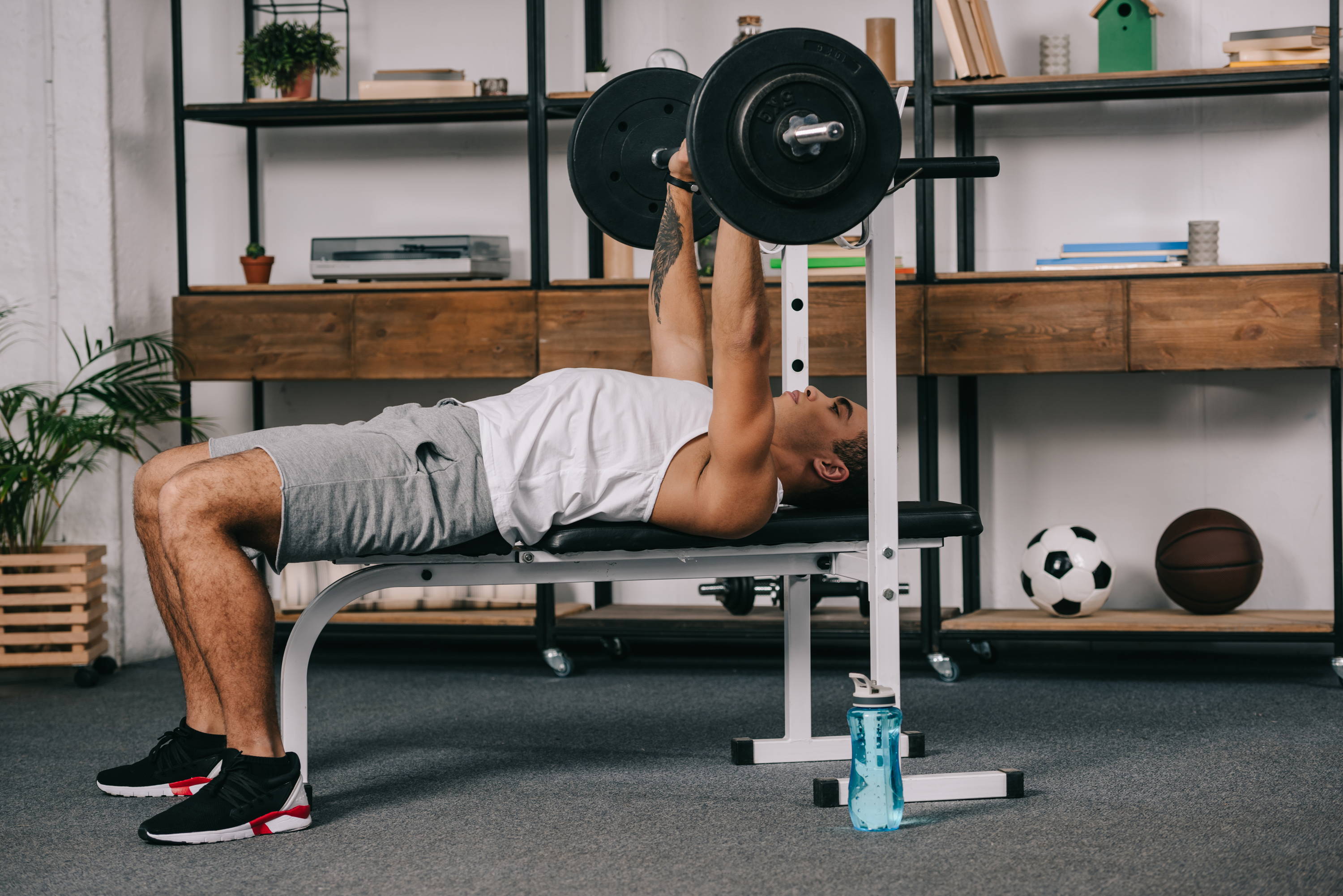 A man working out in his living room on a bench press