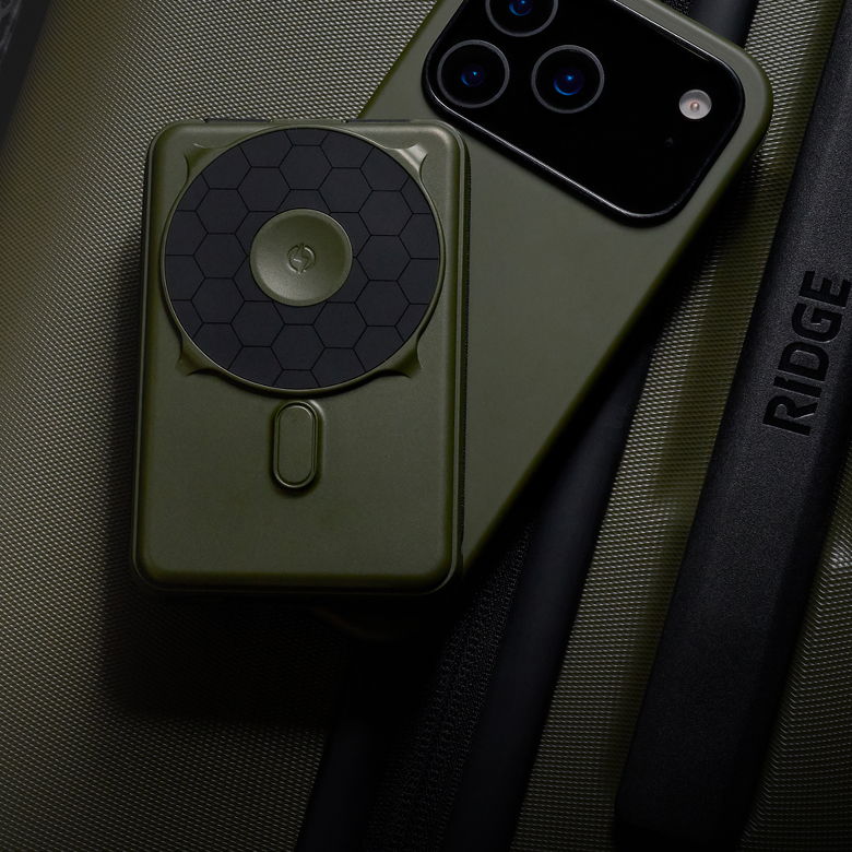 Smartphone with a green case and circular accessory on a dark background.