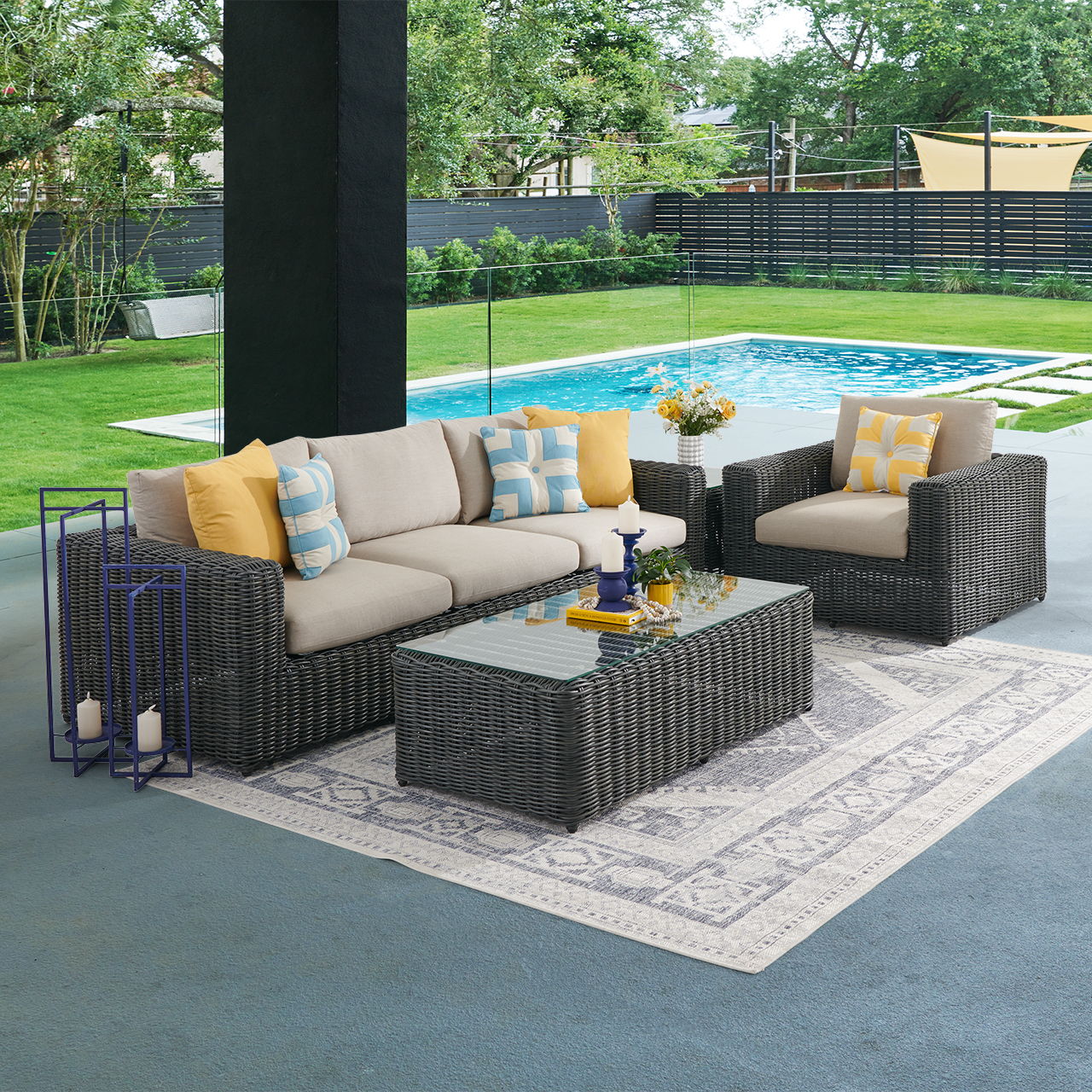 Outdoor seating area with a pool, featuring a sofa, chairs, and coffee table.